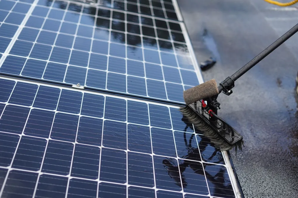 Cleaning solar panels with a brush