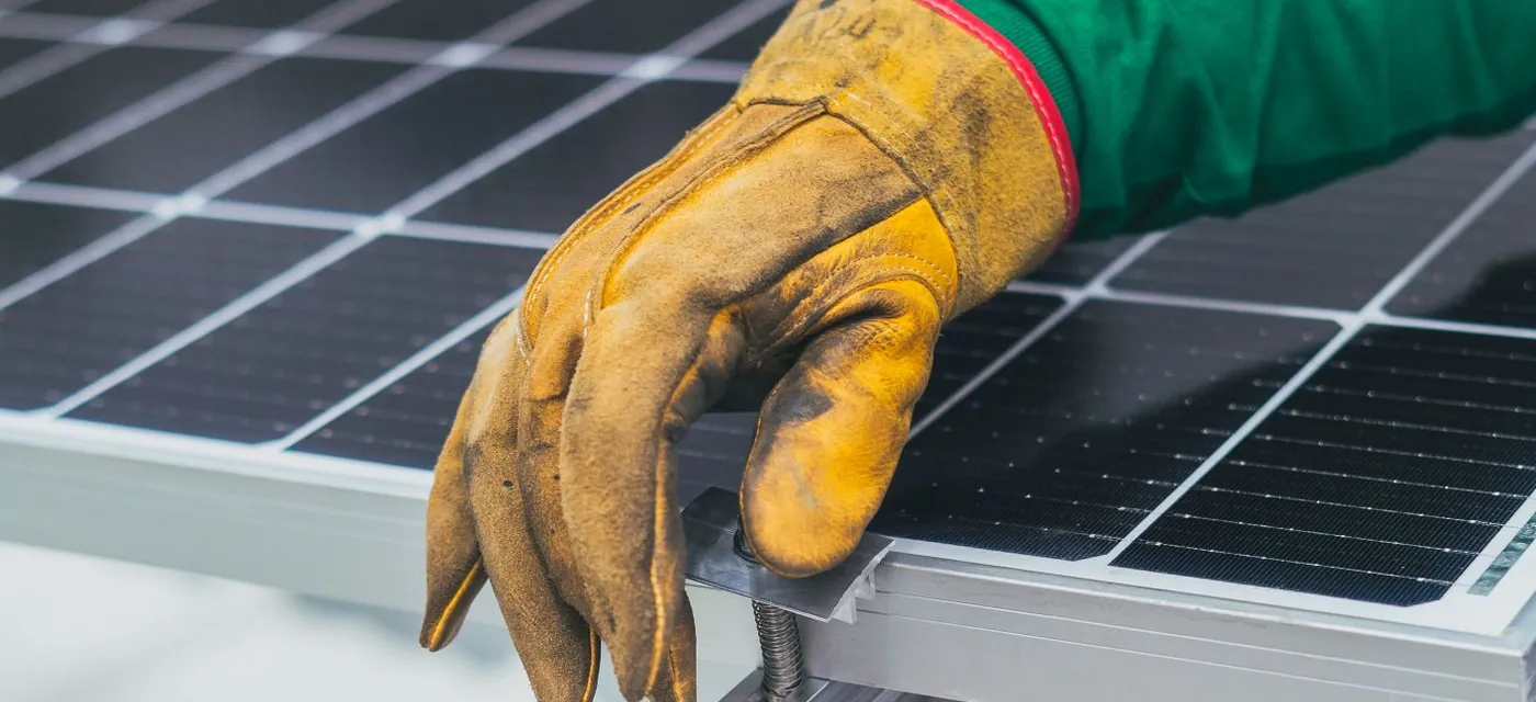 Installer fixing a solar panel to its mounting rail